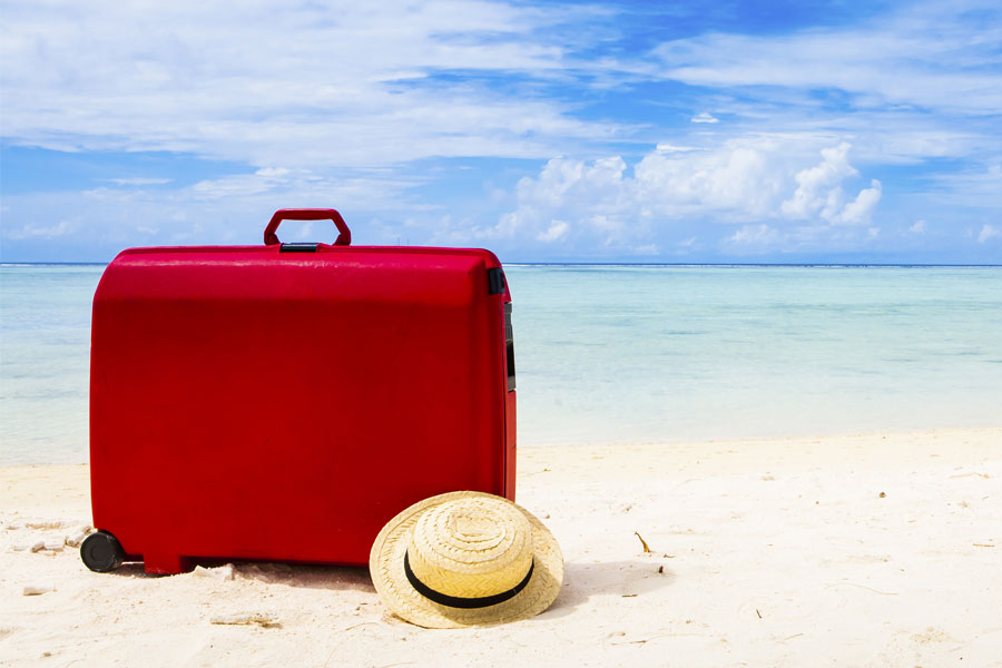 Punainen matkalaukku rannalla